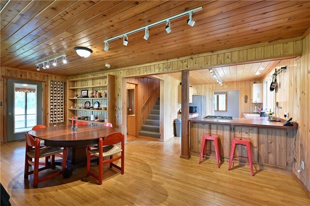 12642 Paddock Rd, Hayward, WI 54843 - dining area with track lighting, wood walls, stairs, light wood finished floors, and wood ceiling