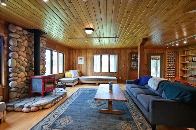 12642 Paddock Rd, Hayward, WI 54843 - living area featuring track lighting, a wood stove, wood finished floors, wooden ceiling, and wooden walls