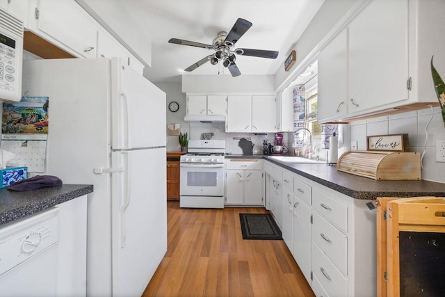 N2356 County Road D Ft, Atkinson, WI 53538 - kitchen featuring white appliances, a sink, light wood finished floors, dark countertops, and backsplash