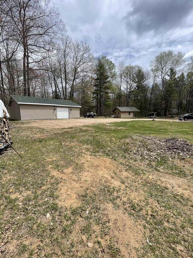 N18355 Big Bear Rd, Pembine, WI 54156 - view of grassy yard with a detached garage, an outdoor structure, and view of scattered trees