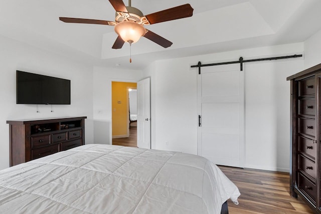 3410 Tulip Trl, Appleton, WI 54913 - bedroom featuring a barn door, wood finished floors, a tray ceiling, baseboards, and ceiling fan