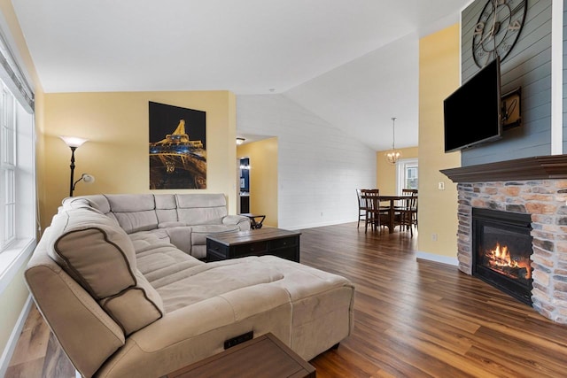 3410 Tulip Trl, Appleton, WI 54913 - living area featuring a chandelier, dark wood-style flooring, vaulted ceiling, baseboards, and a stone fireplace