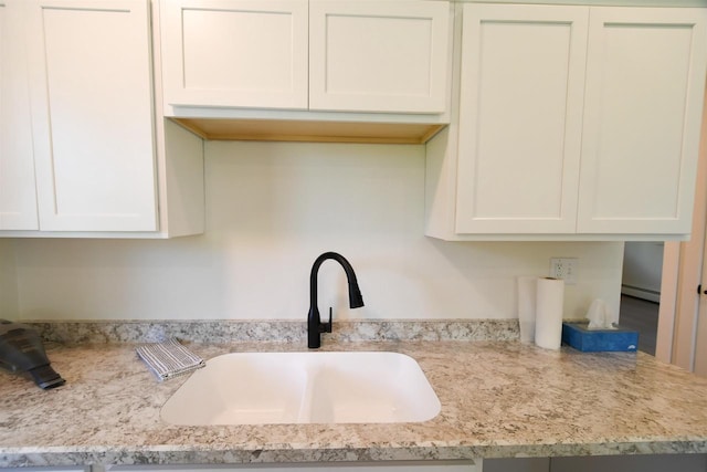 W13414 Liner Rd, Brandon, WI 53919 - kitchen with a sink, baseboard heating, white cabinetry, and light stone counters