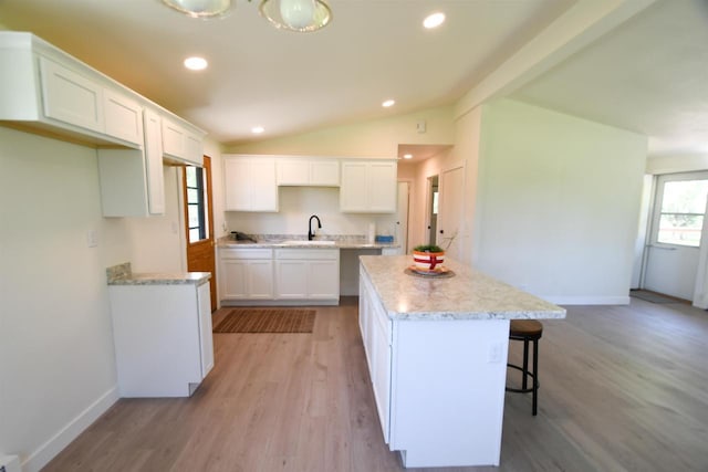 W13414 Liner Rd, Brandon, WI 53919 - kitchen featuring a sink, a kitchen island, lofted ceiling, baseboards, and white cabinetry