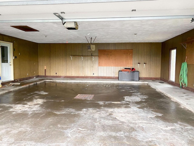 831 County Road Ig, Livingston, WI 53554 - garage with wood walls, a garage door opener, and baseboards