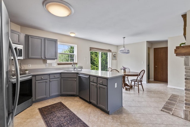 1293 Chesterwood Ln, Pewaukee, WI 53072 - kitchen featuring appliances with stainless steel finishes, a peninsula, gray cabinetry, a sink, and light countertops