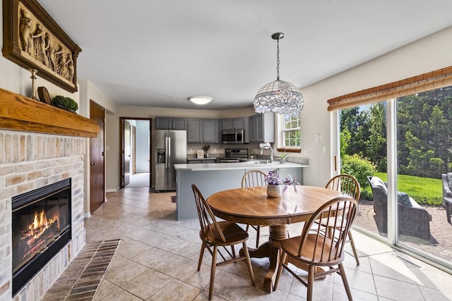 1293 Chesterwood Ln, Pewaukee, WI 53072 - dining room featuring light tile patterned flooring and a brick fireplace
