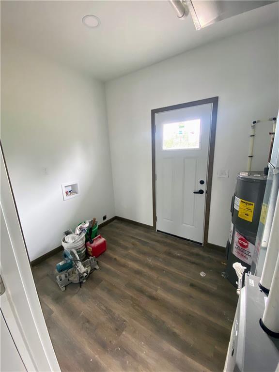202 Huset Ln, Dallas, WI 54733 - foyer entrance featuring water heater, dark wood finished floors, and baseboards