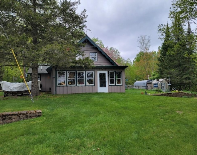 4055W Lester Ln, Loretta, WI 54896 - back of house featuring board and batten siding, a lawn, and an outbuilding