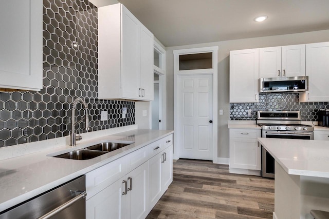 241 E Hubert St, Edgerton, WI 53534 - kitchen with appliances with stainless steel finishes, a sink, backsplash, light countertops, and light wood finished floors