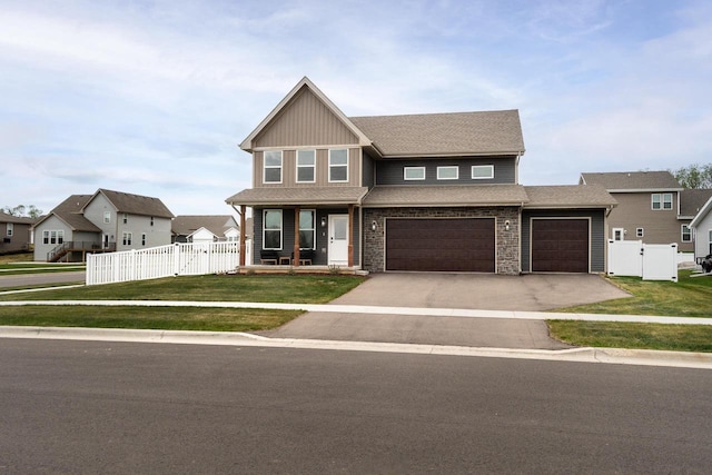 241 E Hubert St, Edgerton, WI 53534 - craftsman-style home with a gate, covered porch, driveway, a garage, and board and batten siding