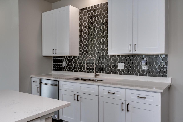 241 E Hubert St, Edgerton, WI 53534 - kitchen featuring a sink, white cabinetry, tasteful backsplash, and light stone countertops