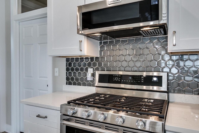 241 E Hubert St, Edgerton, WI 53534 - kitchen with appliances with stainless steel finishes, tasteful backsplash, and white cabinetry