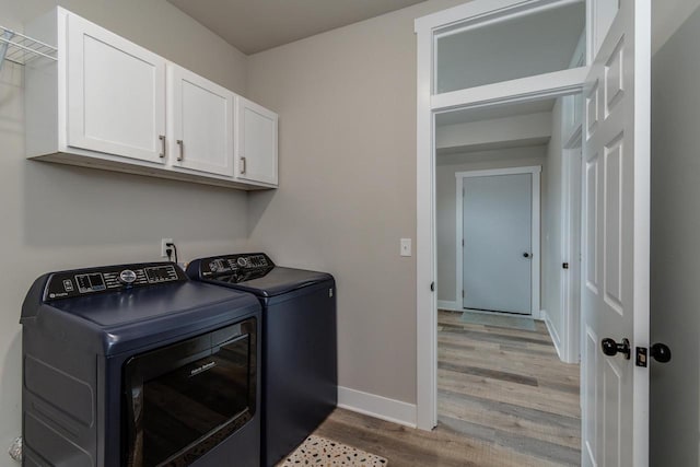 241 E Hubert St, Edgerton, WI 53534 - laundry room with washing machine and clothes dryer, light wood-type flooring, baseboards, and cabinet space