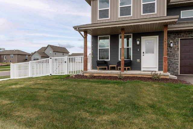 241 E Hubert St, Edgerton, WI 53534 - view of front of property featuring a porch, a garage, stone siding, and board and batten siding