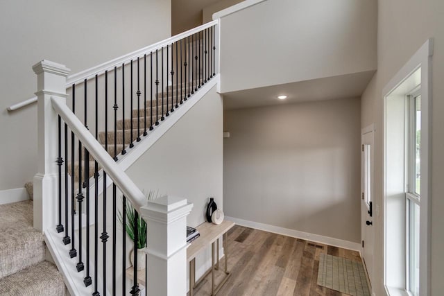 241 E Hubert St, Edgerton, WI 53534 - stairway with baseboards, wood finished floors, and a high ceiling