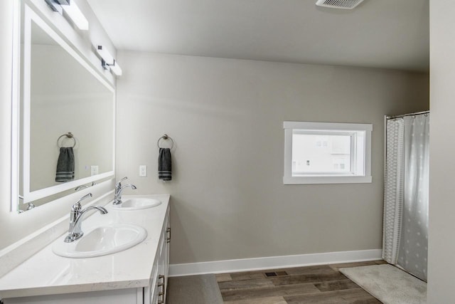 241 E Hubert St, Edgerton, WI 53534 - bathroom with double vanity, wood finished floors, and baseboards