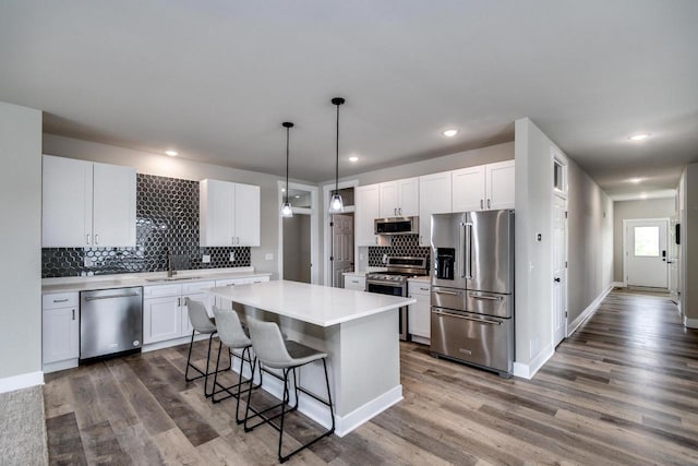 241 E Hubert St, Edgerton, WI 53534 - kitchen with appliances with stainless steel finishes, a sink, decorative backsplash, light countertops, and white cabinets