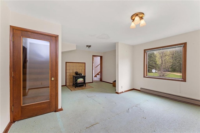 N7681 Jagielo Rd, Pittsville, WI 54466 - unfurnished living room featuring baseboards, a wood stove, a baseboard radiator, and stairway