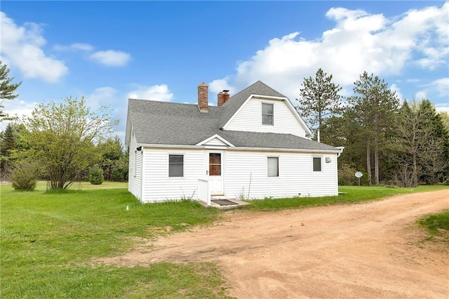 N7681 Jagielo Rd, Pittsville, WI 54466 - rear view of property featuring a chimney, roof with shingles, driveway, and a yard