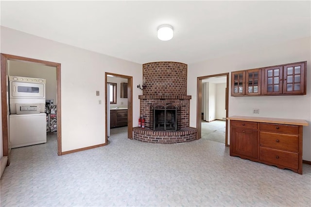 N7681 Jagielo Rd, Pittsville, WI 54466 - living room featuring stacked washing machine and dryer, baseboards, and a fireplace