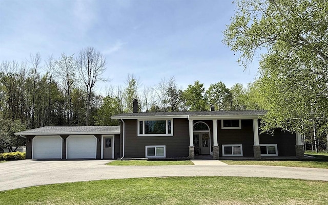 W6896 # 2 Rd, Menominee, MI 49858 - bi-level home featuring driveway, an attached garage, a front lawn, and a chimney