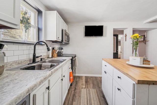 1578 Cass St, Green Bay, WI 54302 - kitchen with appliances with stainless steel finishes, wood counters, a sink, dark wood-style flooring, and backsplash