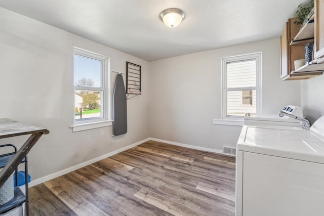 1578 Cass St, Green Bay, WI 54302 - washroom featuring separate washer and dryer, wood finished floors, baseboards, and cabinet space
