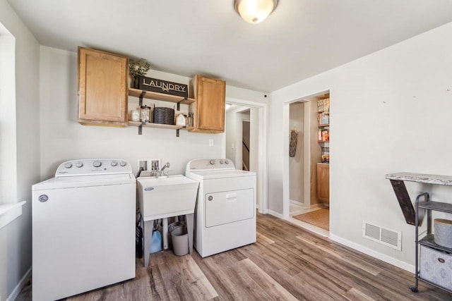 1578 Cass St, Green Bay, WI 54302 - laundry room with cabinet space, separate washer and dryer, wood finished floors, and baseboards