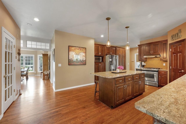 1516 Bradbury Ct, Green Bay, WI 54313 - kitchen with stainless steel appliances, wood finished floors, baseboards, a center island, and a breakfast bar area