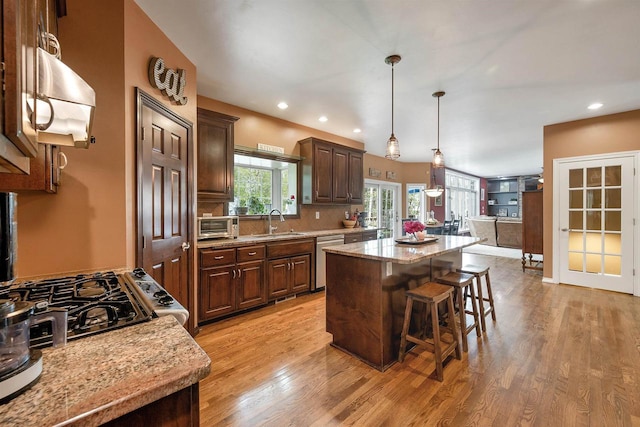 1516 Bradbury Ct, Green Bay, WI 54313 - kitchen featuring a sink, a kitchen island, dishwasher, a kitchen breakfast bar, and light wood-style floors