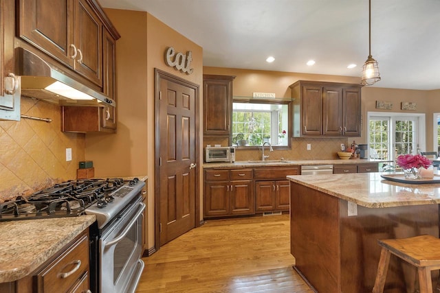 1516 Bradbury Ct, Green Bay, WI 54313 - kitchen featuring stainless steel appliances, under cabinet range hood, a sink, decorative backsplash, and light wood-style floors