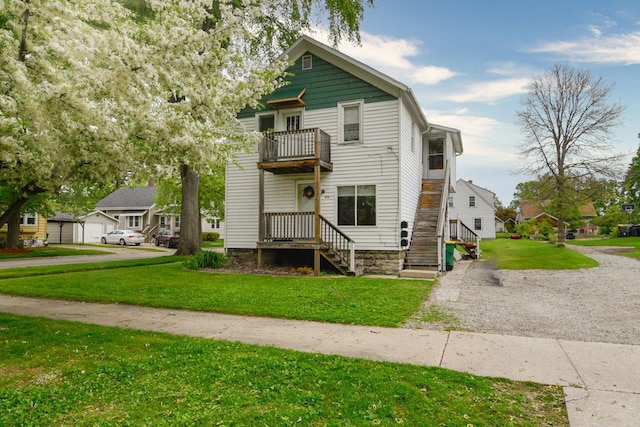 876 Elmore St, Green Bay, WI 54303 - view of front of property featuring a balcony, a front lawn, a residential view, and gravel driveway
