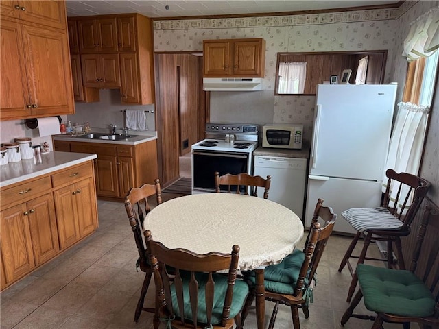 23923 Washington St, Independence, WI 54747 - kitchen featuring white appliances, wallpapered walls, under cabinet range hood, a sink, and brown cabinets