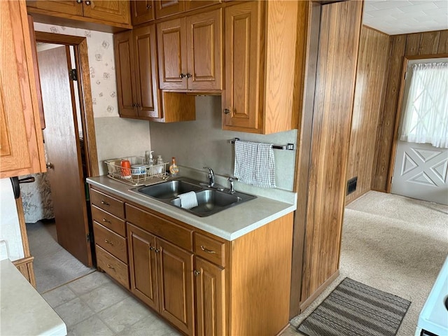 23923 Washington St, Independence, WI 54747 - kitchen with a sink, light countertops, brown cabinetry, and wooden walls