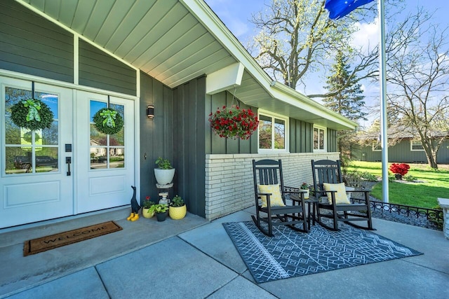 4619 Stonebridge Dr, Racine, WI 53404 - doorway to property with brick siding, french doors, and board and batten siding