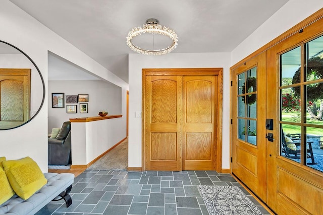 4619 Stonebridge Dr, Racine, WI 53404 - entryway with stone finish floors, baseboards, and a chandelier