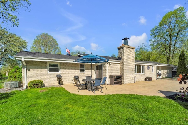 4619 Stonebridge Dr, Racine, WI 53404 - rear view of property with a patio, a chimney, a lawn, and brick siding