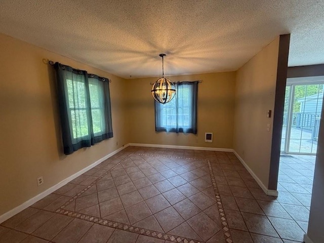 228227 County Road Y, Birnamwood, WI 54414 - unfurnished dining area with a chandelier, tile patterned flooring, inlaid floor details, a textured ceiling, and baseboards