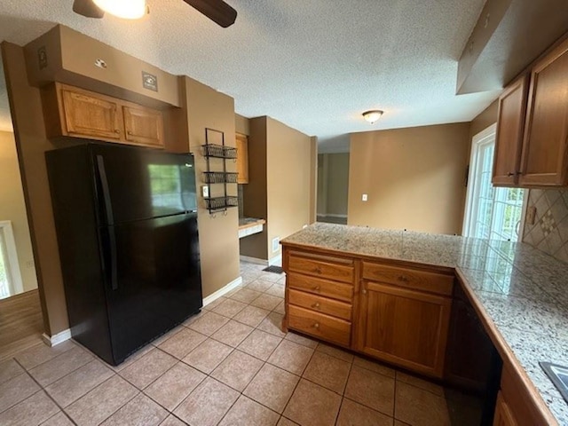 228227 County Road Y, Birnamwood, WI 54414 - kitchen with freestanding refrigerator, tile counters, backsplash, a textured ceiling, and a ceiling fan