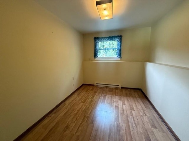 228227 County Road Y, Birnamwood, WI 54414 - empty room with a baseboard heating unit, wood finished floors, and baseboards