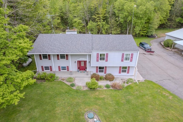228227 County Road Y, Birnamwood, WI 54414 - split foyer home featuring a porch, a front lawn, a view of trees, and roof with shingles