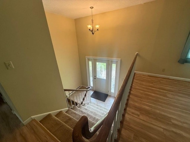 228227 County Road Y, Birnamwood, WI 54414 - staircase with a chandelier, wood finished floors, a textured ceiling, and baseboards
