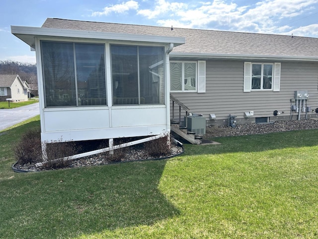 1010 Whispering Winds Pl, Onalaska, WI 54650 - back of property featuring a lawn, a sunroom, a shingled roof, and central AC unit