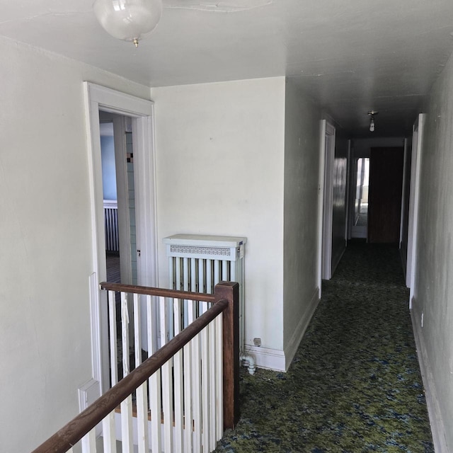 hallway with an upstairs landing and baseboards