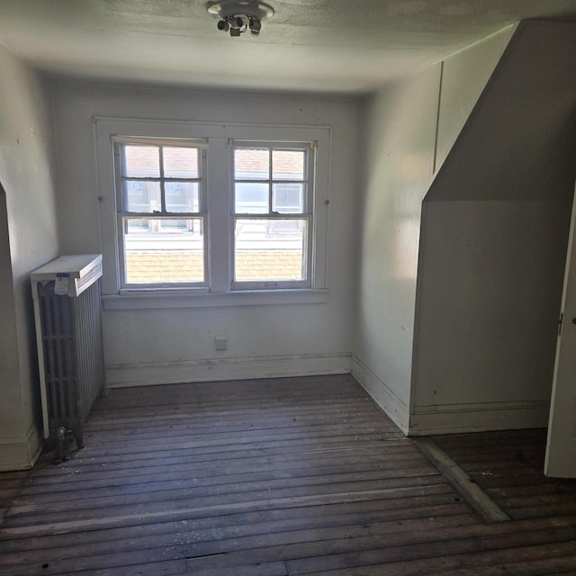 additional living space featuring wood finished floors and baseboards