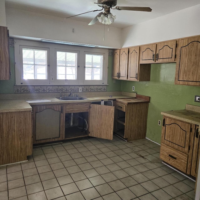 kitchen featuring a ceiling fan, healthy amount of natural light, a sink, and brown cabinetry