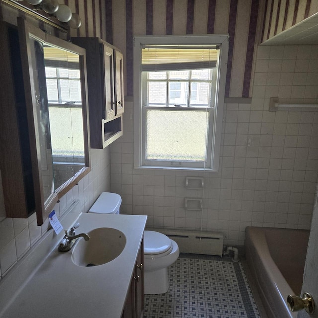 full bath featuring a baseboard heating unit, tile walls, wallpapered walls, healthy amount of natural light, and toilet