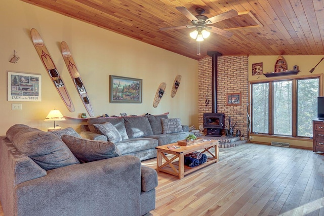 1948 Wild Life Ln, Eagle River, WI 54521 - living area with a wood stove, vaulted ceiling, ceiling fan, wooden ceiling, and wood finished floors