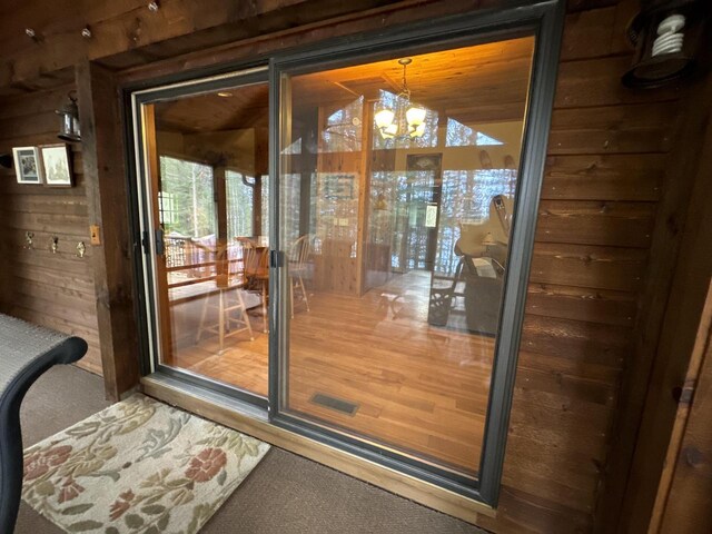 1948 Wild Life Ln, Eagle River, WI 54521 - entryway featuring carpet flooring, a chandelier, and wood walls